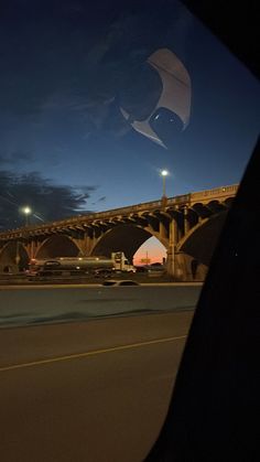 an airplane flying over a bridge at night