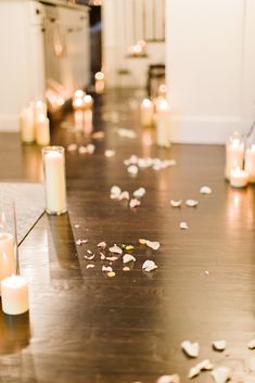 many candles are on the floor with petals