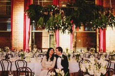 a bride and groom sitting at their wedding reception