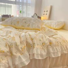 a bed with white sheets and yellow ruffles