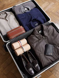 an open suitcase filled with clothes and shoes