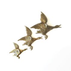 three metal birds flying in the air