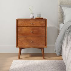 a nightstand with two drawers in a bedroom