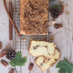 a loaf of bread sitting on top of a metal rack next to nuts and leaves