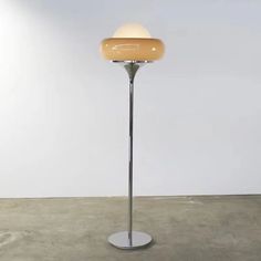 a lamp that is on top of a metal pole in the middle of a room