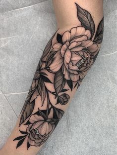 a black and white flower tattoo on the arm