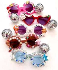 several pairs of sunglasses and disco balls on a white surface