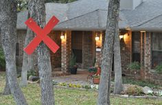 a house with a red x sign in front of it and trees around the yard