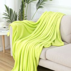 a bright green blanket draped over a white couch