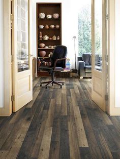 a room with wood flooring and a chair in front of the door that is open