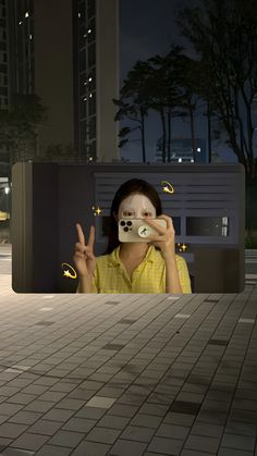 a woman taking a selfie with her cell phone in the city at night time