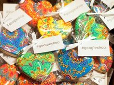 there are many colorful cookies in the box with tags on them that say goggieshop