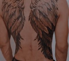 the back of a man with wings on his chest and upper part of his body