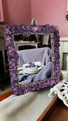 a purple frame sitting on top of a table next to a white bowl and plate