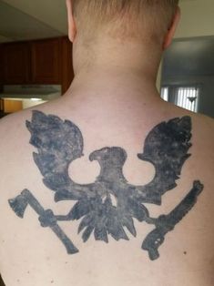 the back of a man's neck with an eagle and wrenches on it