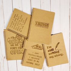 four notebooks with writing on them sitting next to each other