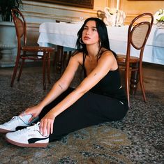 a woman sitting on the floor next to a table