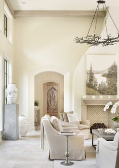 a living room filled with furniture and a chandelier hanging from it's ceiling