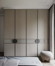 a bed sitting next to a tall wooden cabinet with two doors on it's sides