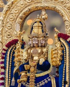 an elaborately decorated gold statue in front of a doorway