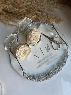 two pairs of glasses sitting on top of a white plate with silver glitter around it