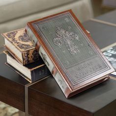 three books sitting on top of a table next to each other in front of a couch