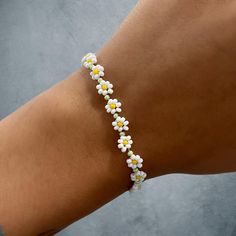 Daisy cabin flower bracelet with silver lobster clasp Flower Shaped Bracelets For Beach, Adjustable White Bracelet With Flower Decoration, Trendy Silver Flower Bracelets, Summer Flower Beaded Bracelets, Trendy Beaded Bracelets With Lobster Clasp, Trendy Flower Bracelets For Friendship, Casual Flower Bracelets For Beach, Trendy Summer Bracelet With Flower Charm, Flower Friendship Bracelets For Beach