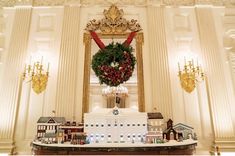 a christmas display in the middle of a room with a wreath on top of it