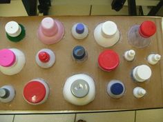 there are many different colored bottles on the table with each one's own lid