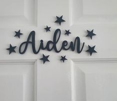 the name arden is made out of black metal stars on a white door with an inscription above it