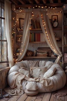 a room filled with lots of books and furniture next to a window covered in fairy lights