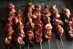 several skewers of meat are being cooked on a grill