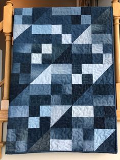 a blue and white quilt hanging from a wooden banister