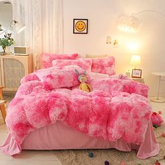 a bed with pink fluffy comforters and pillows