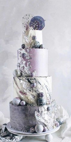 a multi - tiered cake is decorated with marbles