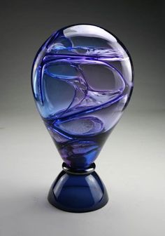 a blue glass vase sitting on top of a table