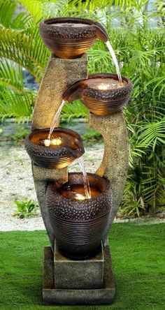 an outdoor fountain with water running from it's sides and three lights on each side