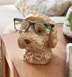 Glasses Holder Additional Storage Space Cockapoo Design Comprised of Resin Never worry about losing your glasses again with this highly-detailed cockapoo glasses holder - an ideal piece to enhance, and brighten, your living space. Comprised of resin, this holder is multifunctional and, with its back storage pocket, also doubles up as a stationery container. With its fun design, this decor is perfect for mantelpieces, end tables and windowsills. Product Dimensions H 16.5cm x W 14cm x D 16cm Compo Air Dry Clay Glasses Holder, Fake Flowers Decor, Dog Holder, Glasses Stand, Storage Desk, Pencil Storage, Glasses Holder, Flowers Decor, Christmas Tree Baubles