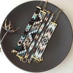 three pieces of beaded jewelry on a black plate