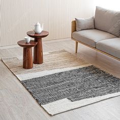 a living room with a couch, coffee table and two side tables on the floor