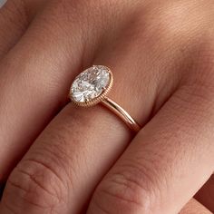 a woman's hand with a diamond ring on top of her finger and an engagement band