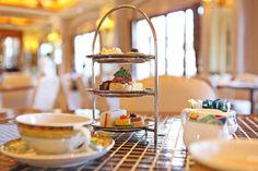 a table topped with plates and cups filled with desserts next to each other on top of a metal rack