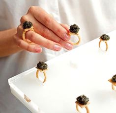 a person holding a tray with food on it and some rings in front of them