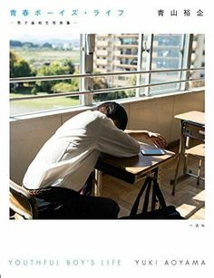 a man sitting at a desk in front of a window looking out on the city