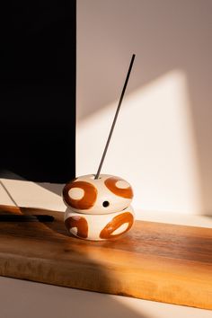 a white and orange object sitting on top of a wooden table