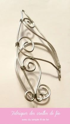 a metal brooch with swirls on it and the words fabringer des orles de jee