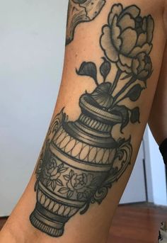 a woman's leg with a bird sitting on top of a cage and flowers