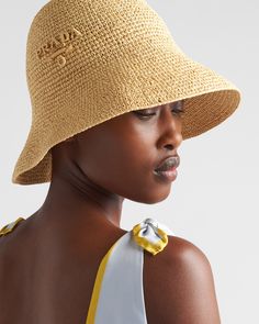 a woman wearing a straw hat with a yellow ribbon around the brimmed top