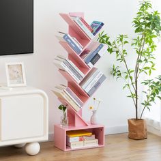 there is a pink shelf with books on it in the living room next to a tv