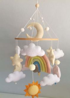 a crib mobile with clouds, rainbows and stars